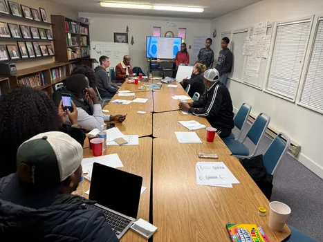 Adults gathered around a meeting table for a Kubana planning workshop